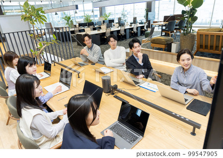 Men and women having a meeting using a monitor 99547905