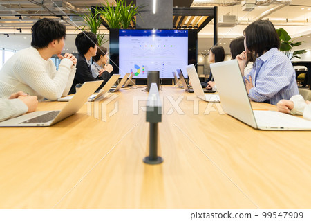 Men and women having a meeting using a monitor 99547909