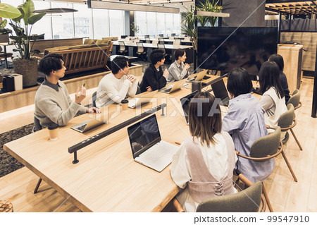 Men and women having a meeting using a monitor 99547910