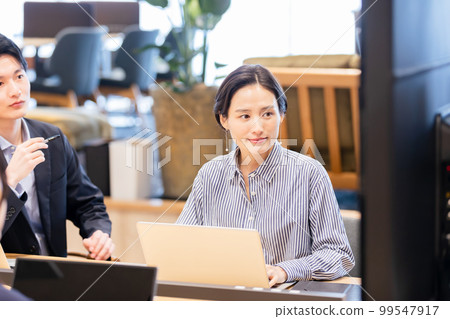 Men and women having a meeting using a monitor Men and women having a meeting using a monitor 99547917