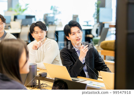 Men and women having a meeting using a monitor Men and women having a meeting using a monitor 99547918