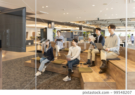 透過玻璃，在時尚設計師的辦公室、分層樓梯工作的人們 99548207