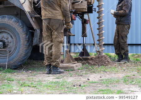 Team of workers with drilling rig on car are drilling artesian well for water in ground. Insertion of metal casing pipe into ground, installation of individual drinking supply, June 28, 2022, Russia, 99549127