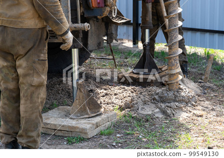 Team of workers with drilling rig on car are drilling artesian well for water in ground. Insertion of metal casing pipe into ground, installation of individual drinking supply, June 28, 2022, Russia, Team of workers with drilling rig on car are drilling artesian well for water in ground. Insertion of metal casing pipe into ground, installation of individual drinking supply, June 28, 2022, Russia, 99549130