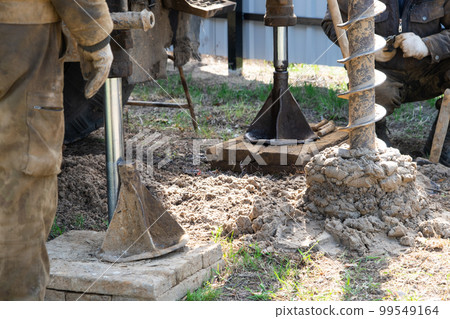 Team of workers with drilling rig on car are drilling artesian well for water in ground. Insertion of metal casing pipe into ground, installation of individual drinking supply, June 28, 2022, Russia, Team of workers with drilling rig on car are drilling artesian well for water in ground. Insertion of metal casing pipe into ground, installation of individual drinking supply, June 28, 2022, Russia, 99549164