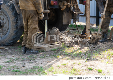 Team of workers with drilling rig on car are drilling artesian well for water in ground. Insertion of metal casing pipe into ground, installation of individual drinking supply, June 28, 2022, Russia, 99549167