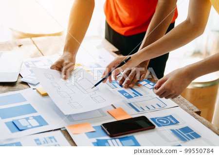 UX developer and ui designer brainstorming about mobile app interface wireframe design with customer breif and color code at modern office.. 99550784