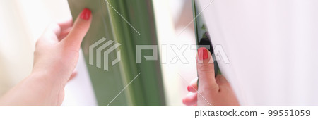 Woman tries to open door by holding window or door handle 99551059