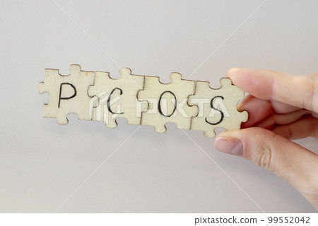 Polycystic Ovarian Syndrome. Hand Writing PCOS on wooden puzzles. 99552042
