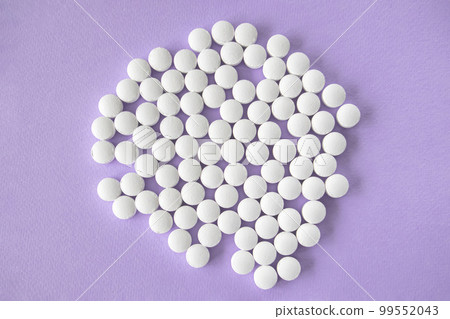 White round tablets, magnesium supplements on a light purple background. 99552043