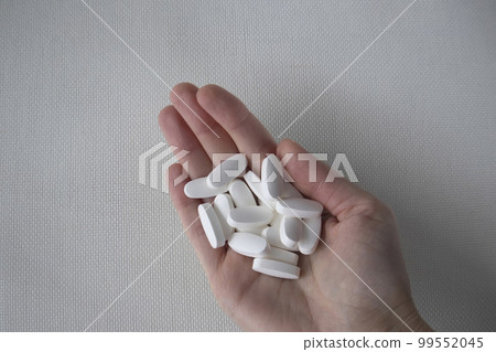 Woman's hand holds white oval pills, pills, vitamins on white background. L glutamine Woman's hand holds white oval pills, pills, vitamins on white background. L glutamine 99552045
