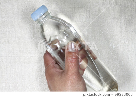 一個男人的手拿著一個裝有水的塑料瓶 99553003