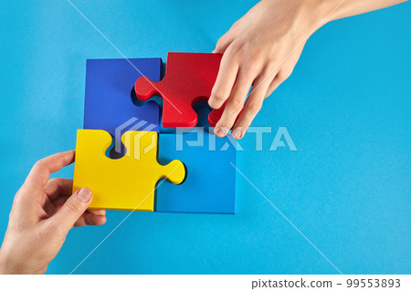 Father and autistic son hands holding jigsaw puzzle shape. World Autism Awareness Day 99553893