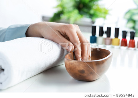 Closeup female hands in wooden bowl with water Closeup female hands in wooden bowl with water 99554942