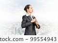 Business woman playing the trumpet 99554943