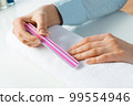 Woman using nail file and create nails shape 99554946