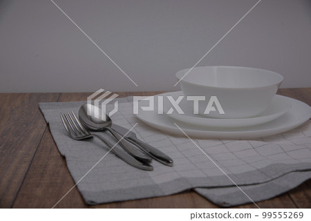 White plates on the wooden surface ,linen napkin, top view of table place White plates on the wooden surface ,linen napkin, top view of table place 99555269