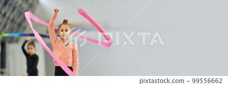 Little girls, children, rhythmic gymnasts training indoors, doing exercise with ribbon. Concept of sport, childhood, rhythmic gymnastics. Banner 99556662