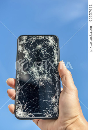 Smartphone with a broken screen after dropping Blue sky back 99557651