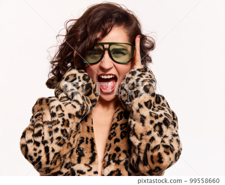Half-length portrait of young beautiful expressive girl posing in stylish animal print furcoat isolated over white background. Concept of beauty, emotions, fashion 99558660