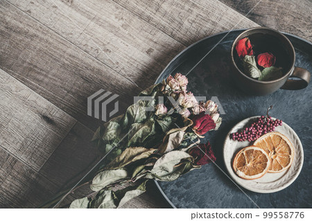 Coffee cup with wood background and flower petals 99558776