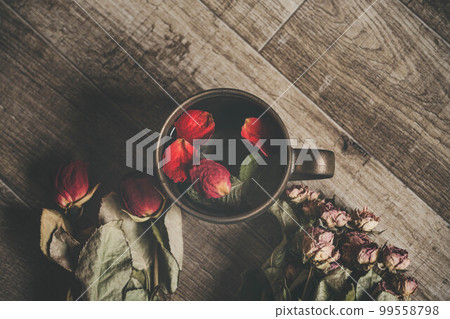 Coffee cup with wood background and flower petals Coffee cup with wood background and flower petals 99558798