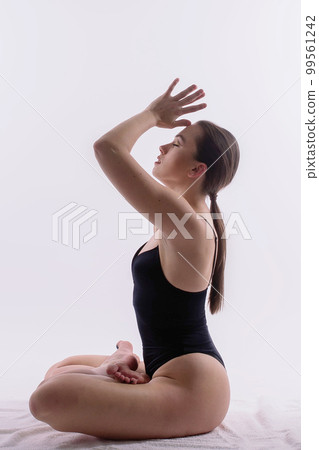 Image of young plump female doing acrobatic stunt, studio shot Image of young plump female doing acrobatic stunt, studio shot 99561242