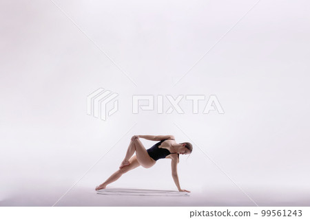 Image of young plump female doing acrobatic stunt, studio shot Image of young plump female doing acrobatic stunt, studio shot 99561243