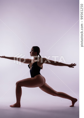 Image of young plump female doing acrobatic stunt, studio shot Image of young plump female doing acrobatic stunt, studio shot 99561250