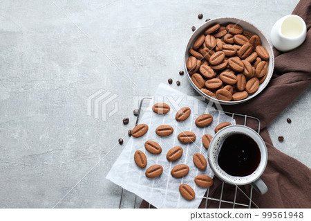 Concept of tasty snack for hot drink - cookies in the shape of coffee seeds Concept of tasty snack for hot drink - cookies in the shape of coffee seeds 99561948