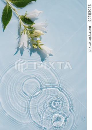 Background with transparent blue water texture with ripples and flowers 99563028