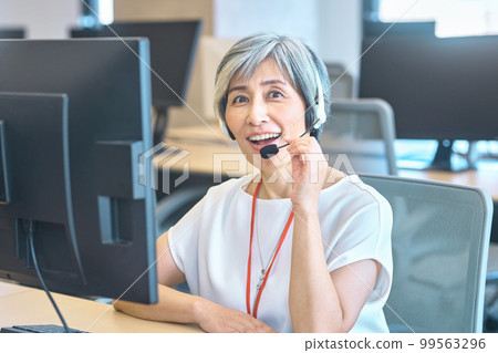 A veteran female operator wearing a headset in the office 99563296