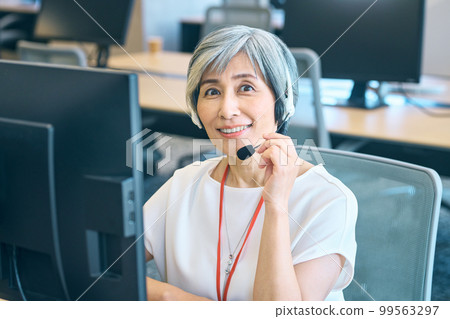 A veteran female operator wearing a headset in the office 99563297