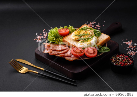 Delicious healthy lunch consisting of bacon, toast, eggs and tomatoes 99563892