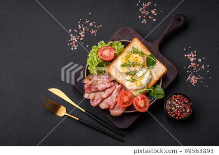 Delicious healthy lunch consisting of bacon, toast, eggs and tomatoes 99563893