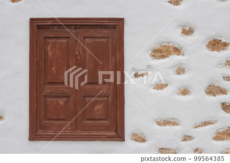 Window and a white facade with stones 99564385