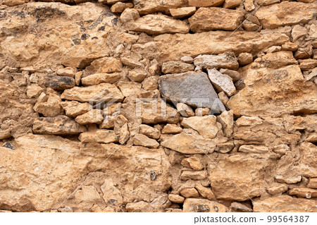 Wall made of uneven natural stones Wall made of uneven natural stones 99564387