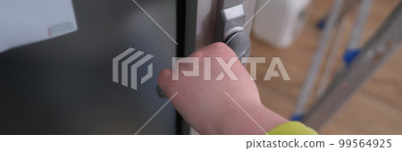 Closeup of woman hand holding and pushing doorknob 99564925