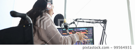 Woman in wheelchair speaks into microphone in front of computer Woman in wheelchair speaks into microphone in front of computer 99564931
