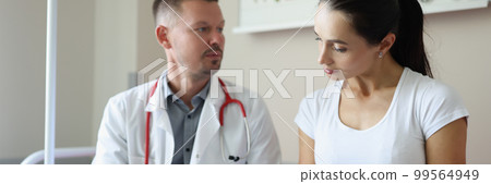 Male doctor communicates with female patient in clinic Male doctor communicates with female patient in clinic 99564949