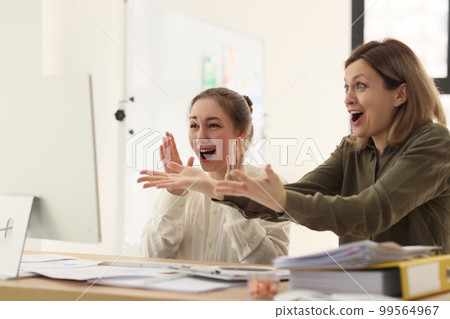 Women in office rejoice while looking at computer screen Women in office rejoice while looking at computer screen 99564967