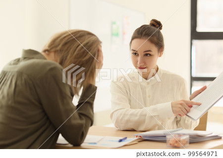 Boss woman shows a mistake for a colleague in documents Boss woman shows a mistake for a colleague in documents 99564971
