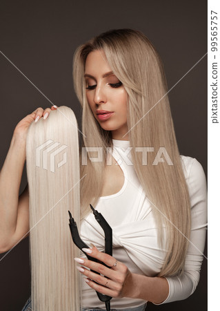 Beautiful blond girl with a perfectly hair, and classic make-up with a strand of hair for extension. Beauty face and hair. Beautiful blond girl with a perfectly hair, and classic make-up with a strand of hair for extension. Beauty face and hair. 99565757