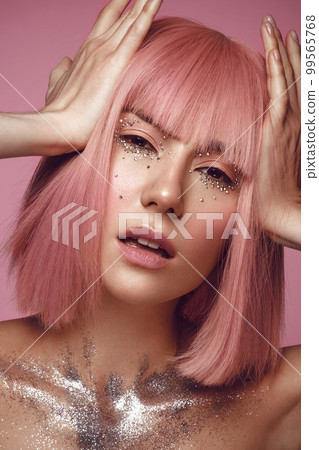 Beautiful woman in a pink wig and creative makeup with rhinestones. Beauty face. 99565768