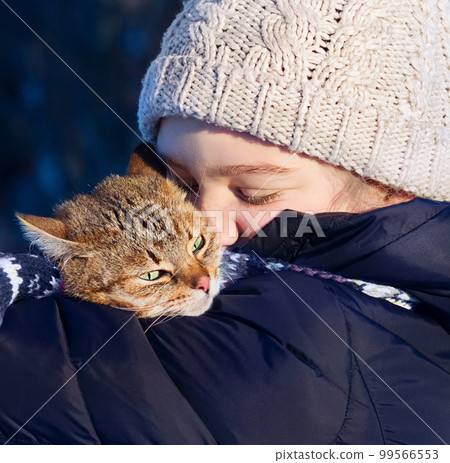Smiling young girl holding her cat outdoors. Smiling young girl holding her cat outdoors. 99566553