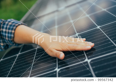 Close up of an engineer hand is checking an operation of sun and cleanliness of photovoltaic solar panels  99567342