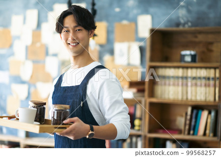 供應可口咖啡的時興的咖啡館職員 99568257