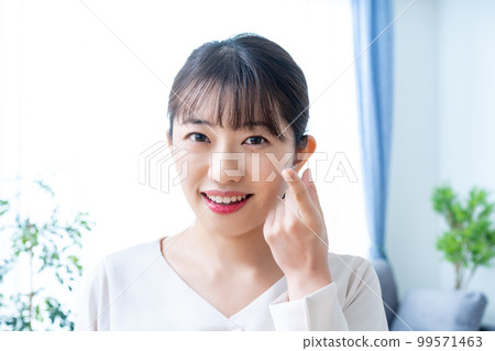 Women trying to wear contact lenses Women trying to wear contact lenses 99571463
