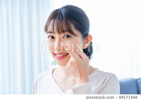 Women trying to wear contact lenses Women trying to wear contact lenses 99571466