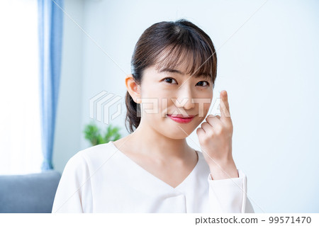 Women trying to wear contact lenses Women trying to wear contact lenses 99571470